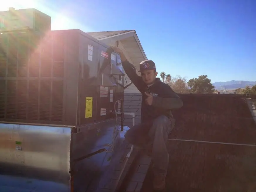 HVAC technician performing HVAC Inspection on a rooftop unit in Robbinsville